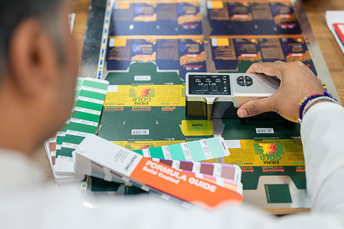 A person is comparing the color for box packaging printing